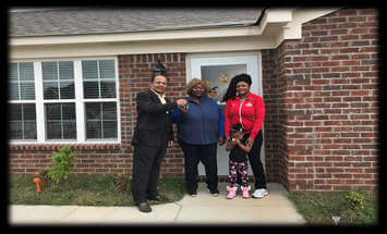 Tunica County CDC’s Executive Director presents Allie and Sandra Williams the keys to their new home.